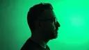 Alejandro Haydar in profile against a vivid green light